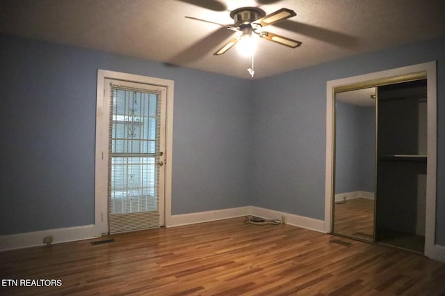 unfurnished bedroom with hardwood / wood-style floors, a textured ceiling, a closet, and ceiling fan