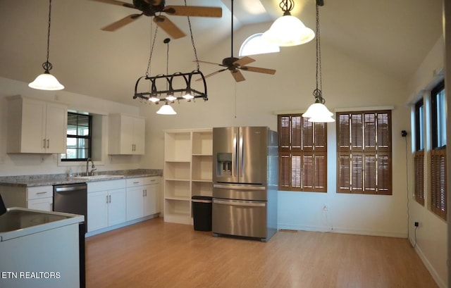 kitchen with light wood-type flooring, appliances with stainless steel finishes, decorative light fixtures, and white cabinetry