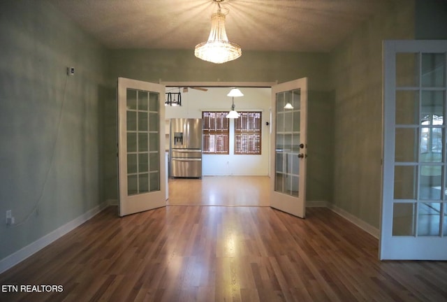 unfurnished dining area featuring french doors, hardwood / wood-style flooring, and a textured ceiling