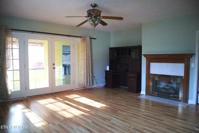 unfurnished living room featuring french doors, hardwood / wood-style floors, and a wealth of natural light