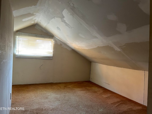 bonus room with carpet flooring and vaulted ceiling