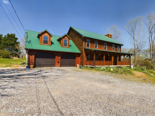 log home with a garage and a porch