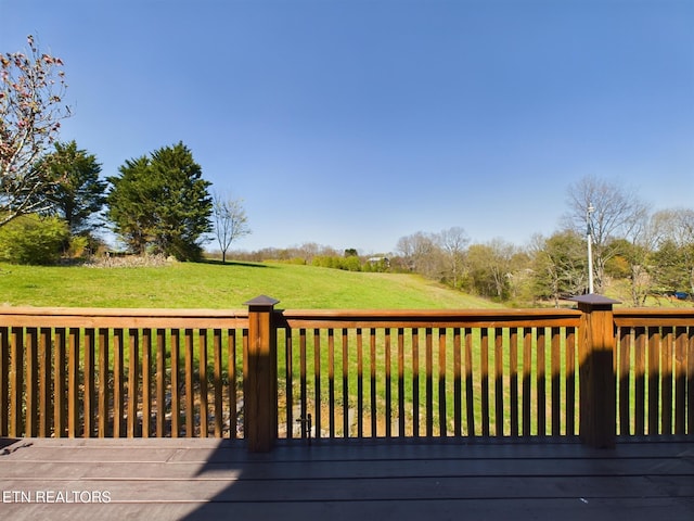 wooden deck featuring a lawn