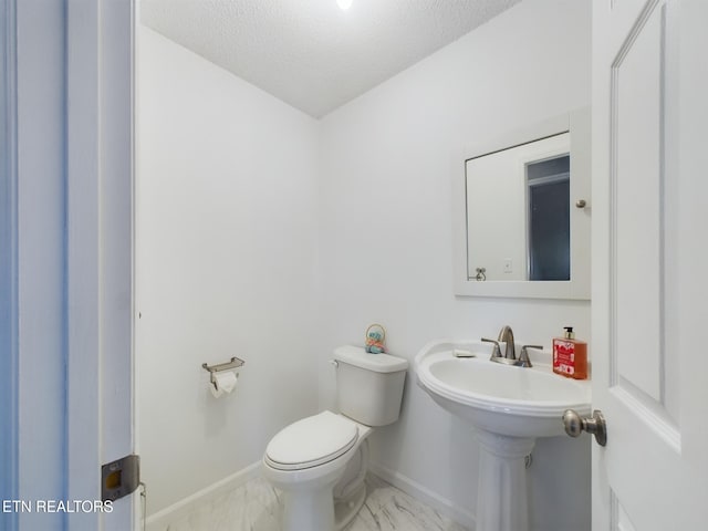 bathroom with a textured ceiling and toilet