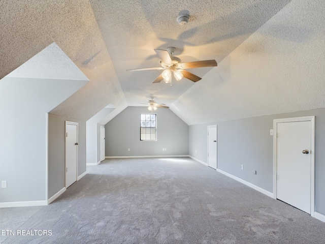 bonus room with carpet, vaulted ceiling, a textured ceiling, and ceiling fan