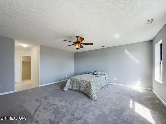 carpeted bedroom featuring a textured ceiling and ceiling fan