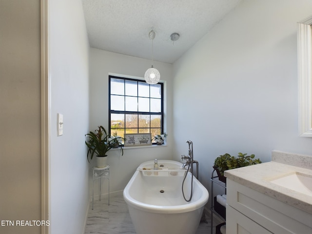 bathroom with vanity, a tub, and a textured ceiling