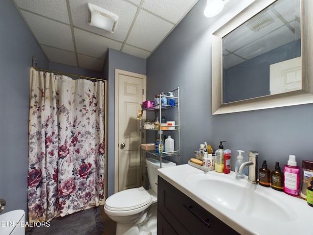 bathroom with vanity, a shower with shower curtain, a paneled ceiling, and toilet