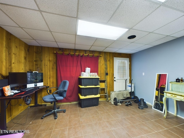 office area featuring a drop ceiling and wooden walls