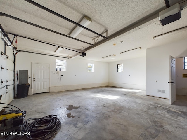 garage with a garage door opener and electric panel