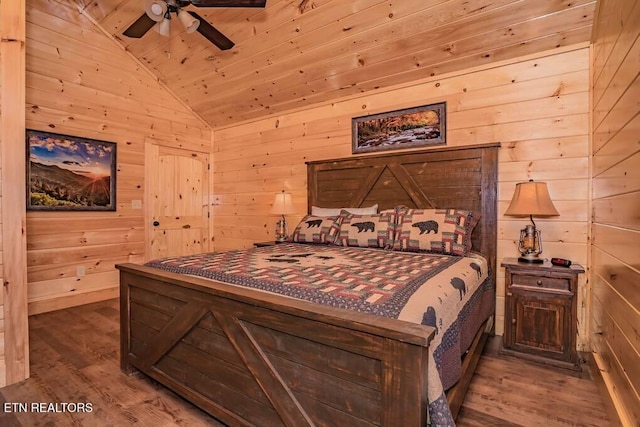 bedroom with lofted ceiling, ceiling fan, hardwood / wood-style flooring, and wood walls