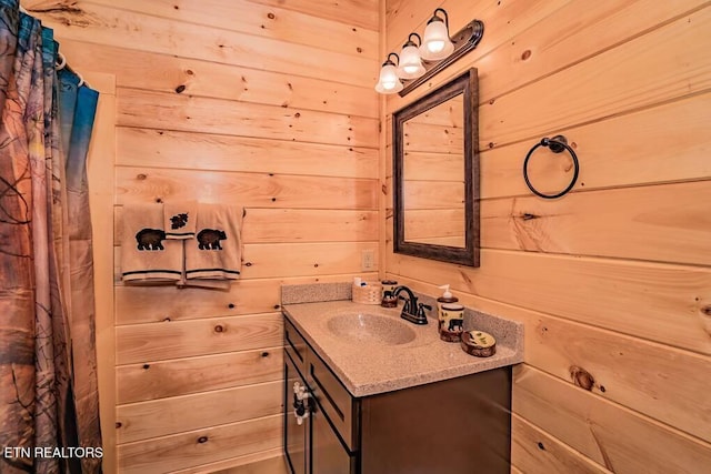 bathroom featuring vanity and wooden walls