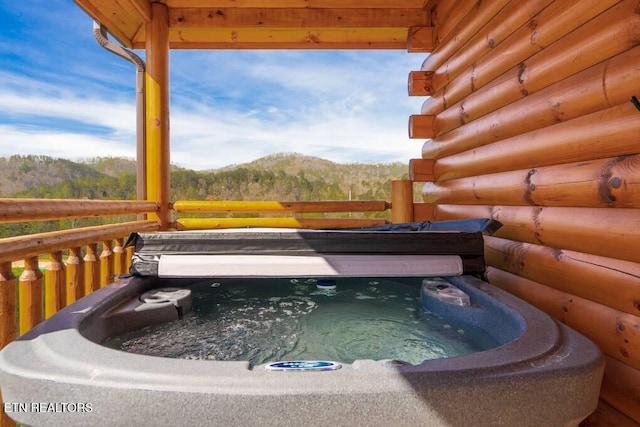 view of swimming pool featuring a hot tub and a mountain view