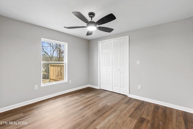 unfurnished bedroom featuring ceiling fan, a closet, and hardwood / wood-style flooring