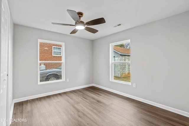 unfurnished room featuring hardwood / wood-style flooring, ceiling fan, and a healthy amount of sunlight