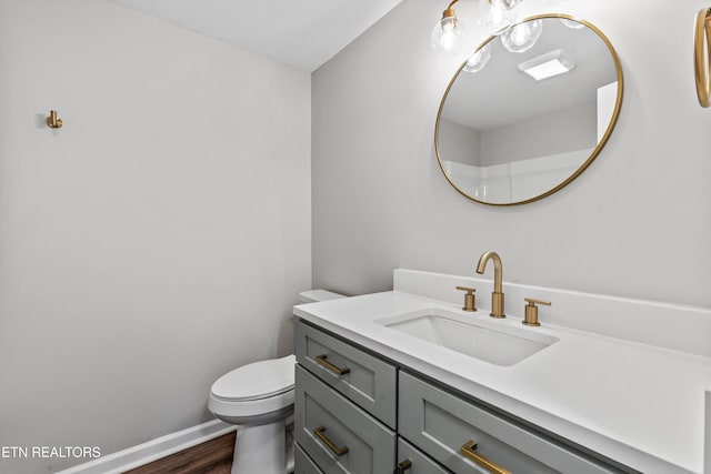 bathroom with hardwood / wood-style flooring, vanity, and toilet