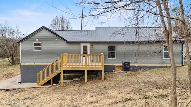 rear view of house with cooling unit and a wooden deck