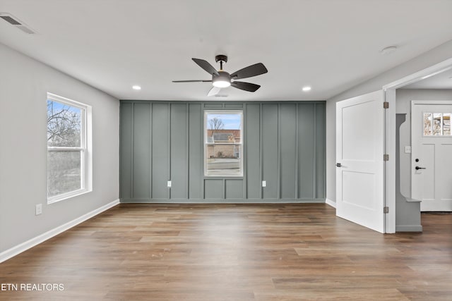 unfurnished room featuring light wood-type flooring, a wealth of natural light, and ceiling fan