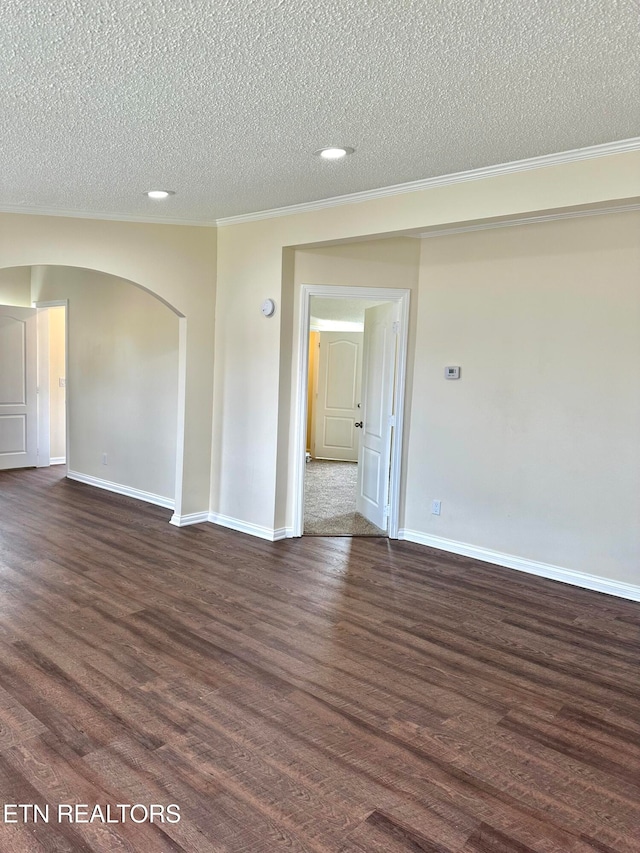 spare room with dark wood-type flooring, a textured ceiling, and crown molding