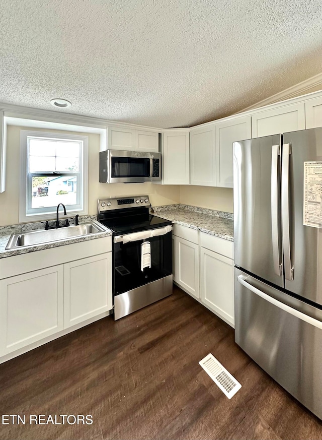 kitchen with stainless steel appliances, dark hardwood / wood-style floors, white cabinets, and sink