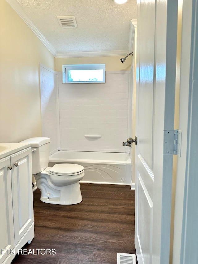 full bathroom featuring ornamental molding, vanity, a textured ceiling, hardwood / wood-style flooring, and toilet