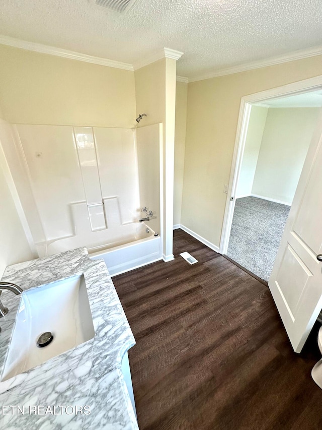 bathroom featuring hardwood / wood-style flooring, a textured ceiling, sink, and shower / bathtub combination