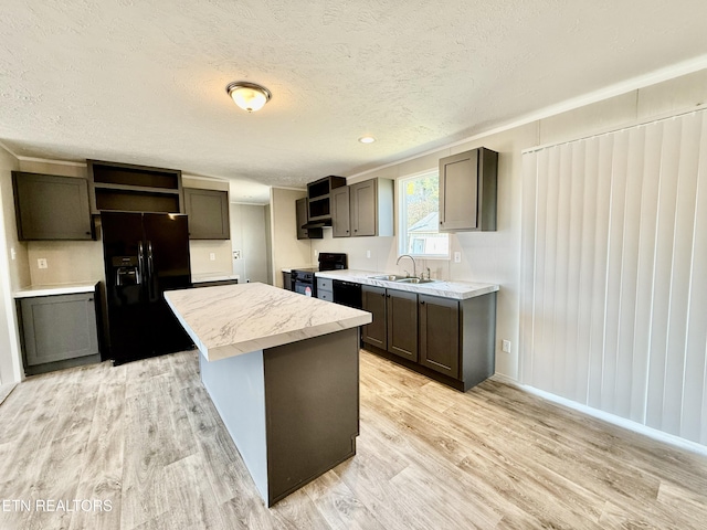 kitchen featuring light countertops, a sink, black appliances, and open shelves