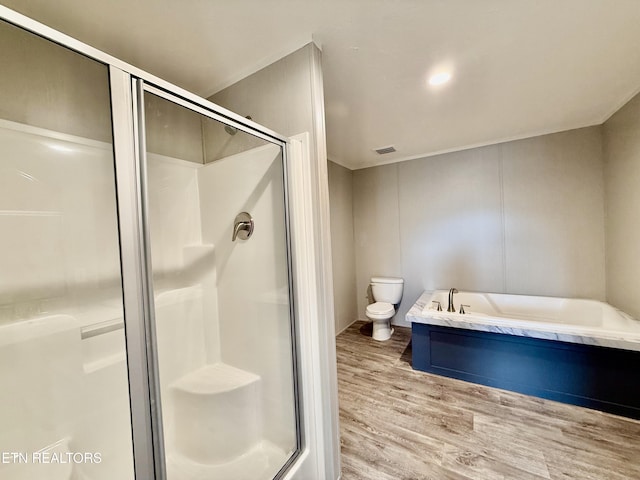 full bathroom with visible vents, toilet, wood finished floors, a shower stall, and a bath