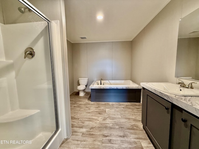 full bath featuring a stall shower, visible vents, toilet, wood finished floors, and vanity