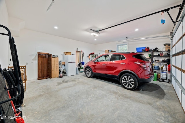 garage with a garage door opener and white fridge