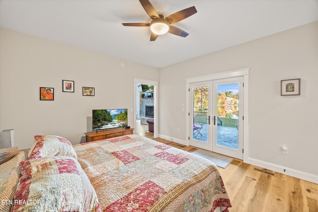 bedroom with access to outside, french doors, light wood-type flooring, and ceiling fan