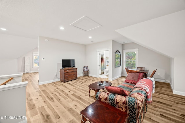 living room with vaulted ceiling and light wood-type flooring