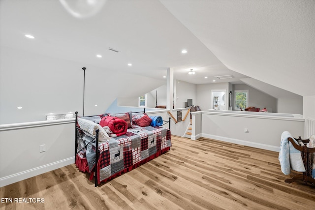 bedroom with lofted ceiling and light hardwood / wood-style flooring