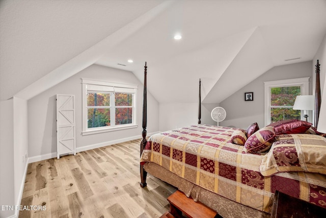 bedroom featuring lofted ceiling and light wood-type flooring