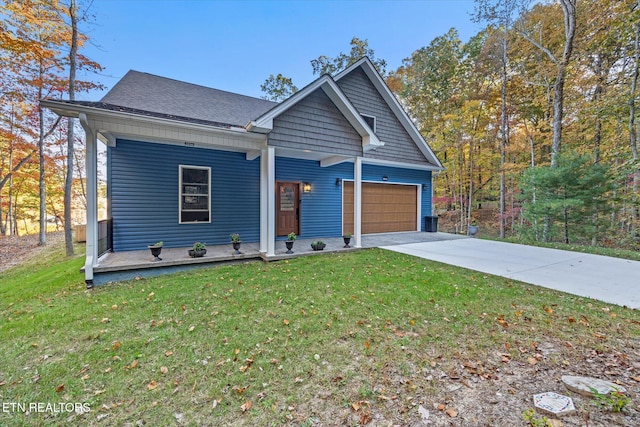 view of front of home featuring covered porch, a front lawn, and a garage