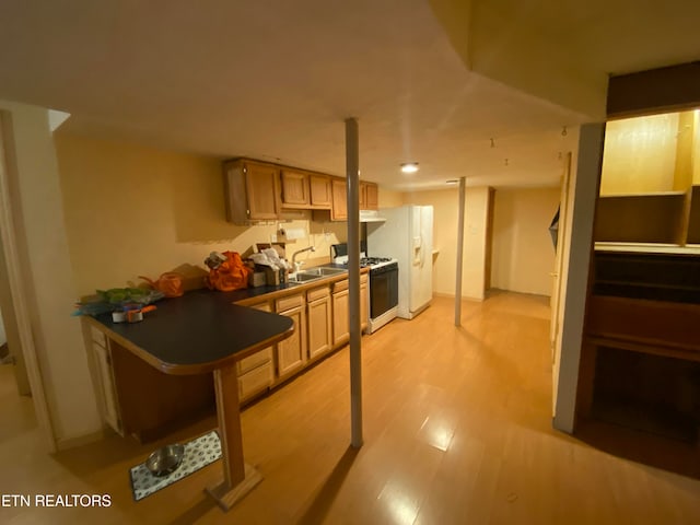 kitchen with light brown cabinets, white appliances, sink, and light hardwood / wood-style floors