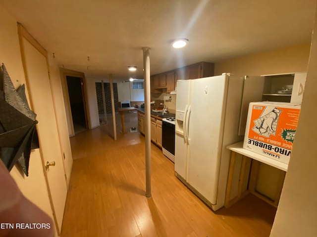 kitchen featuring light hardwood / wood-style flooring, sink, and white appliances