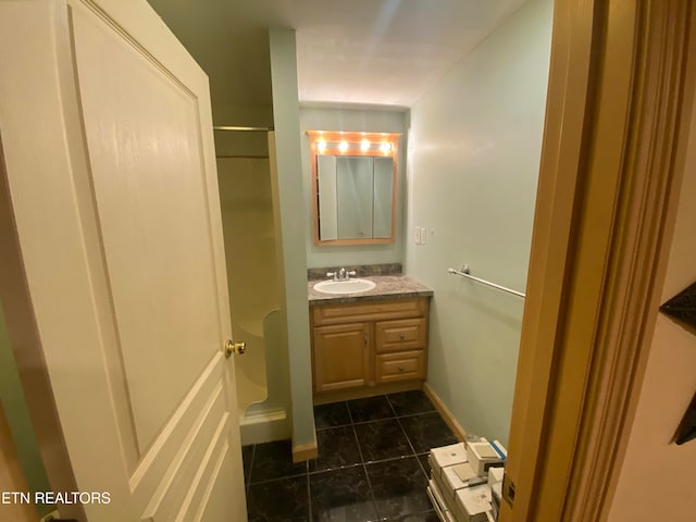 bathroom featuring walk in shower, tile patterned flooring, and vanity