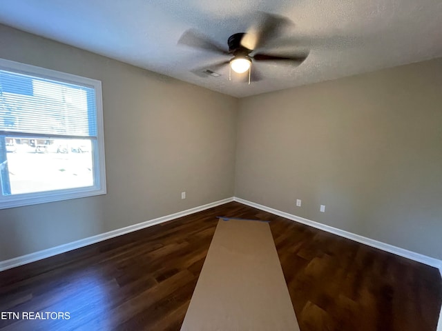 unfurnished room with dark wood-type flooring, a textured ceiling, and ceiling fan