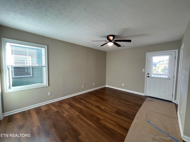 foyer entrance with a textured ceiling, ceiling fan, and dark hardwood / wood-style flooring