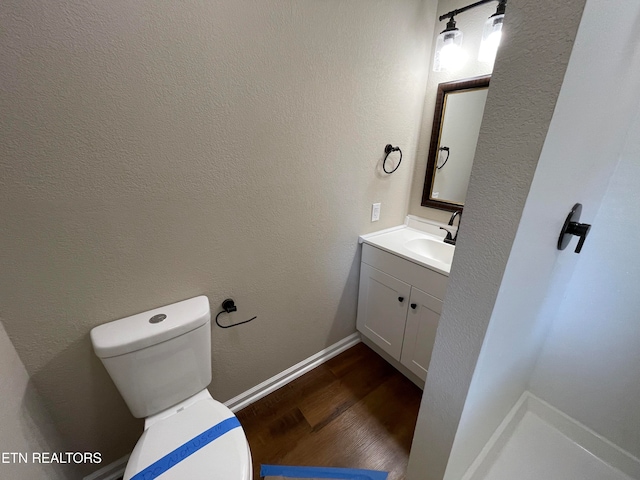 bathroom with vanity, toilet, and wood-type flooring