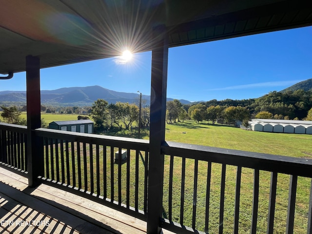 deck with a mountain view and a lawn