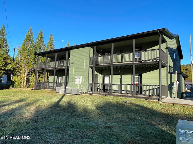 back of property featuring a balcony, a yard, cooling unit, and a patio area