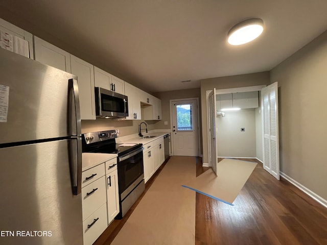 kitchen featuring white cabinetry, appliances with stainless steel finishes, sink, and dark wood-type flooring