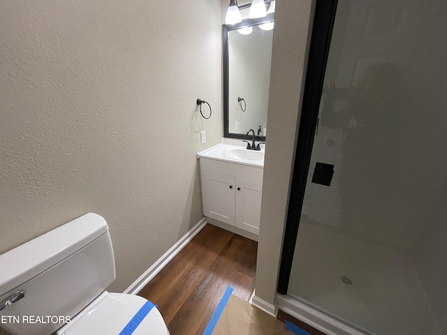 bathroom with vanity, toilet, a shower, and hardwood / wood-style floors