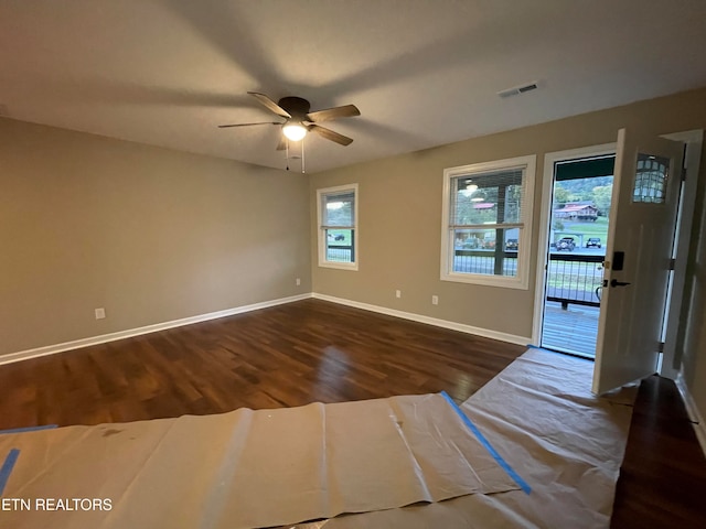 spare room featuring dark wood-type flooring and ceiling fan