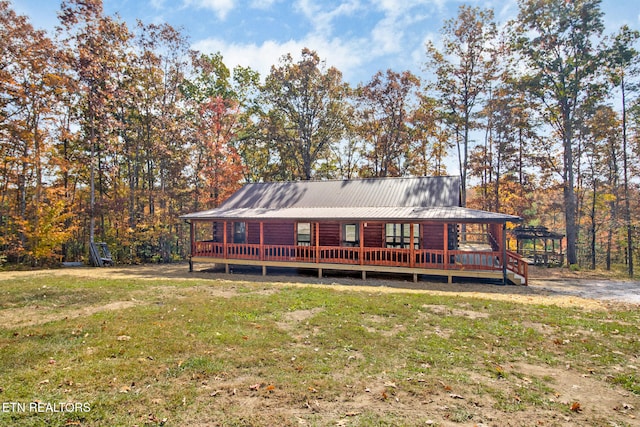 back of house with a wooden deck and a lawn