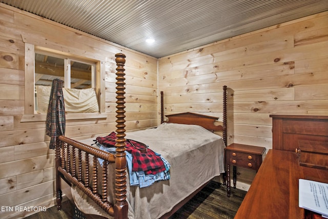 bedroom featuring dark wood-type flooring and wood walls