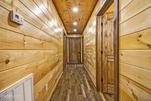 corridor featuring wood walls, wooden ceiling, and dark hardwood / wood-style flooring