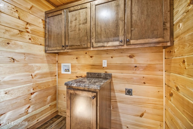 clothes washing area with cabinets, hookup for a washing machine, wooden walls, and electric dryer hookup